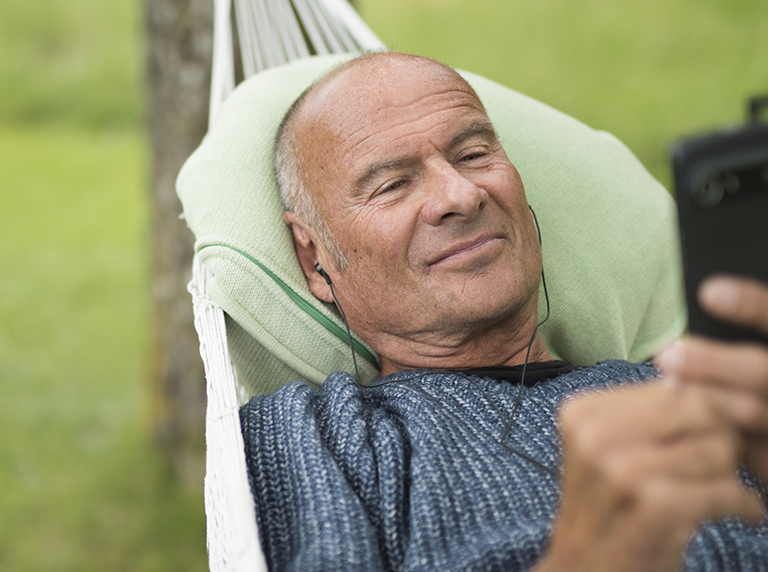 Lasse Holm in hammock using a Doro smartphone.