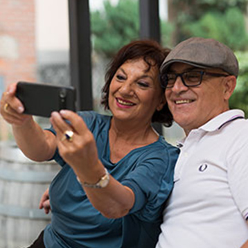 Woman using a Doro smartphone to snap a selfie with her grandchildren.