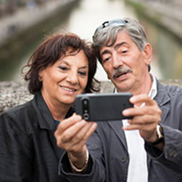 Woman listening to music with a Doro smartphone and headphones.