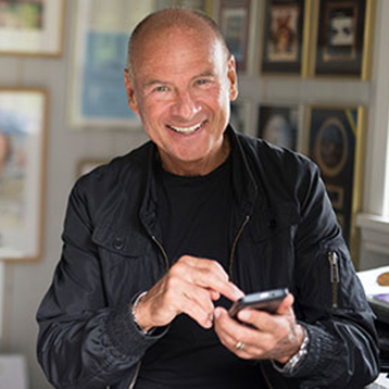 Lasse Holm holding a Doro smartphone.