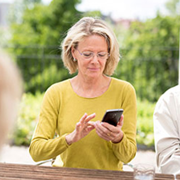 Woman using a Doro smartphone at a table.