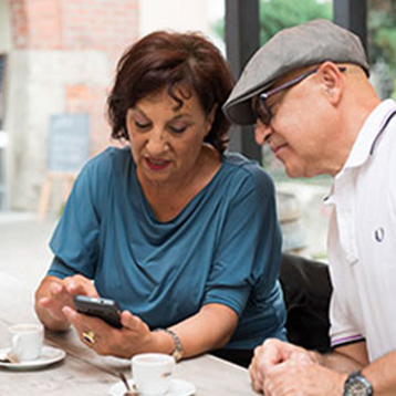 Three people at a table, looking at a Doro smartphone.